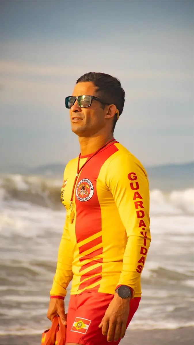 Hermes com o uniforme de guarda-vidas, na beira do mar em Barra Velha